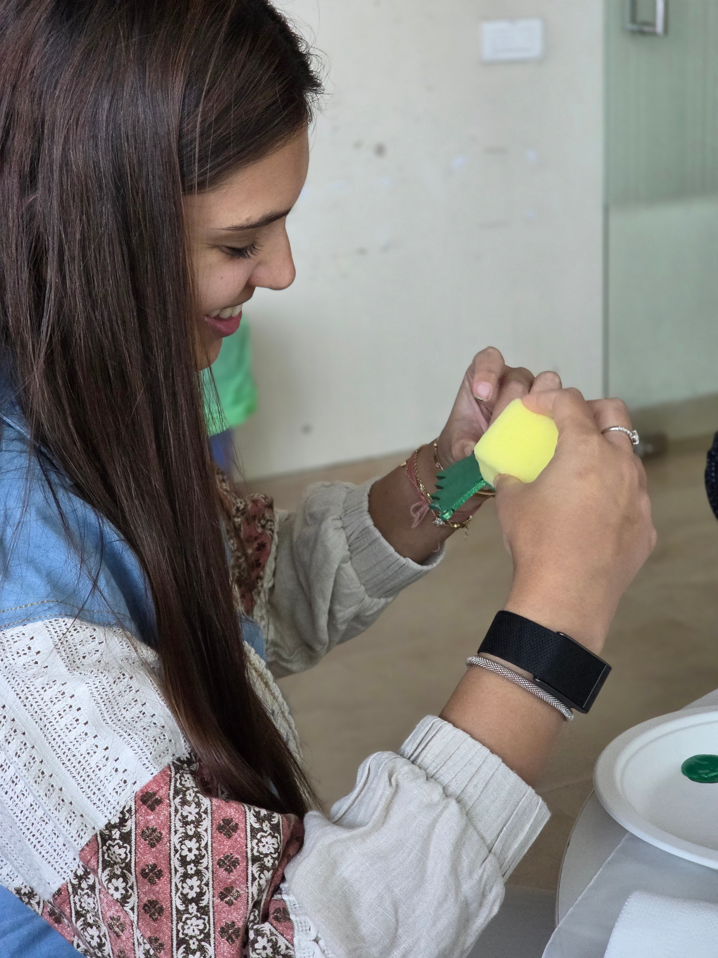 A participant focusing closely on a colorful hands-on art activity